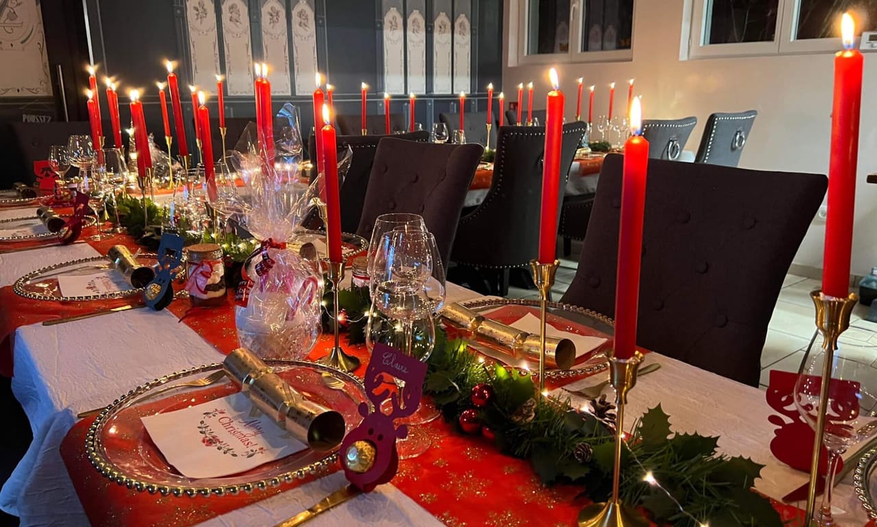 Table de fête dressée par Extrav'Agence : bougies rouges, vaisselle dorée et chemins de table